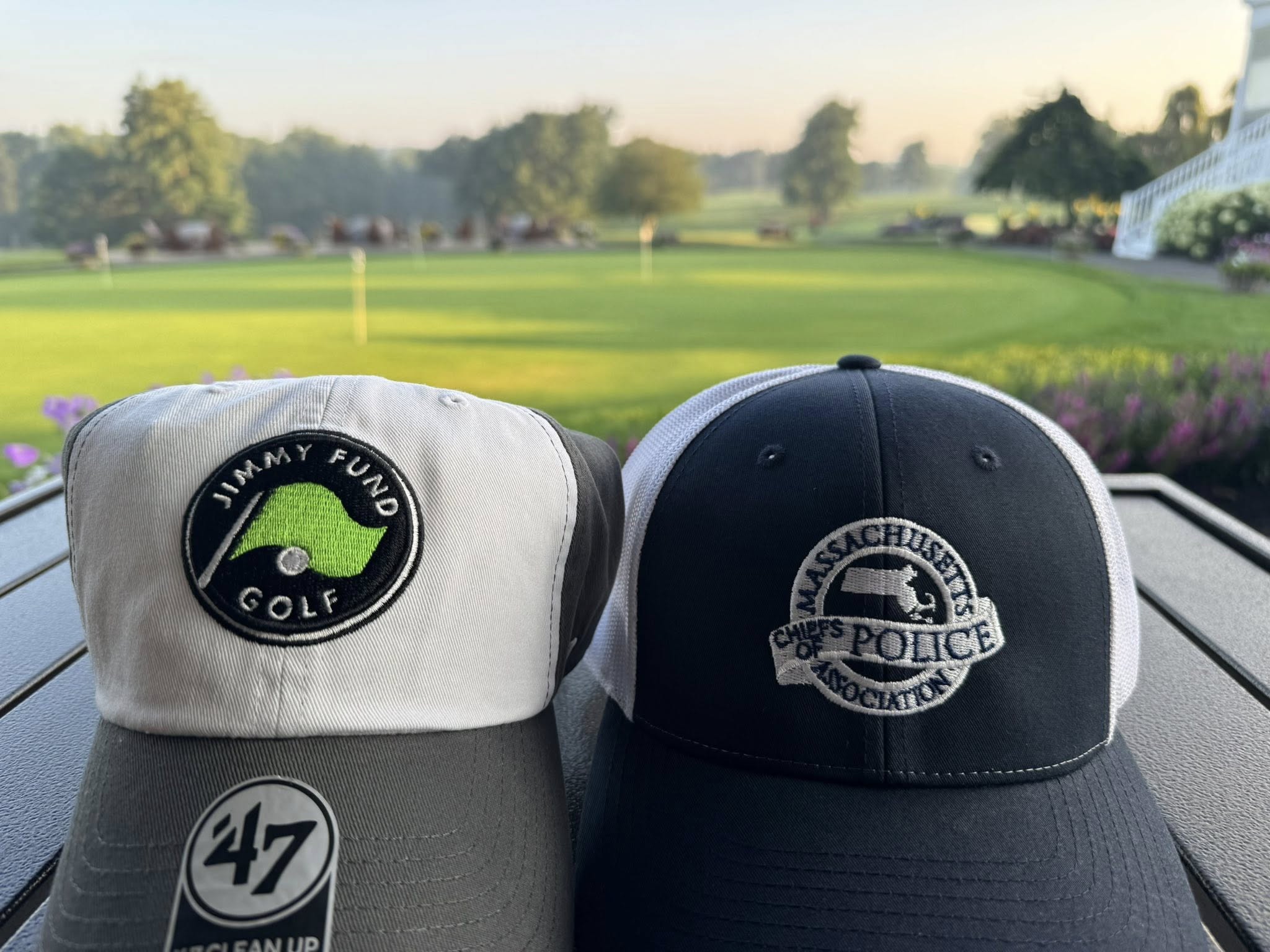Two golf hats sitting on. a table on a golf course.